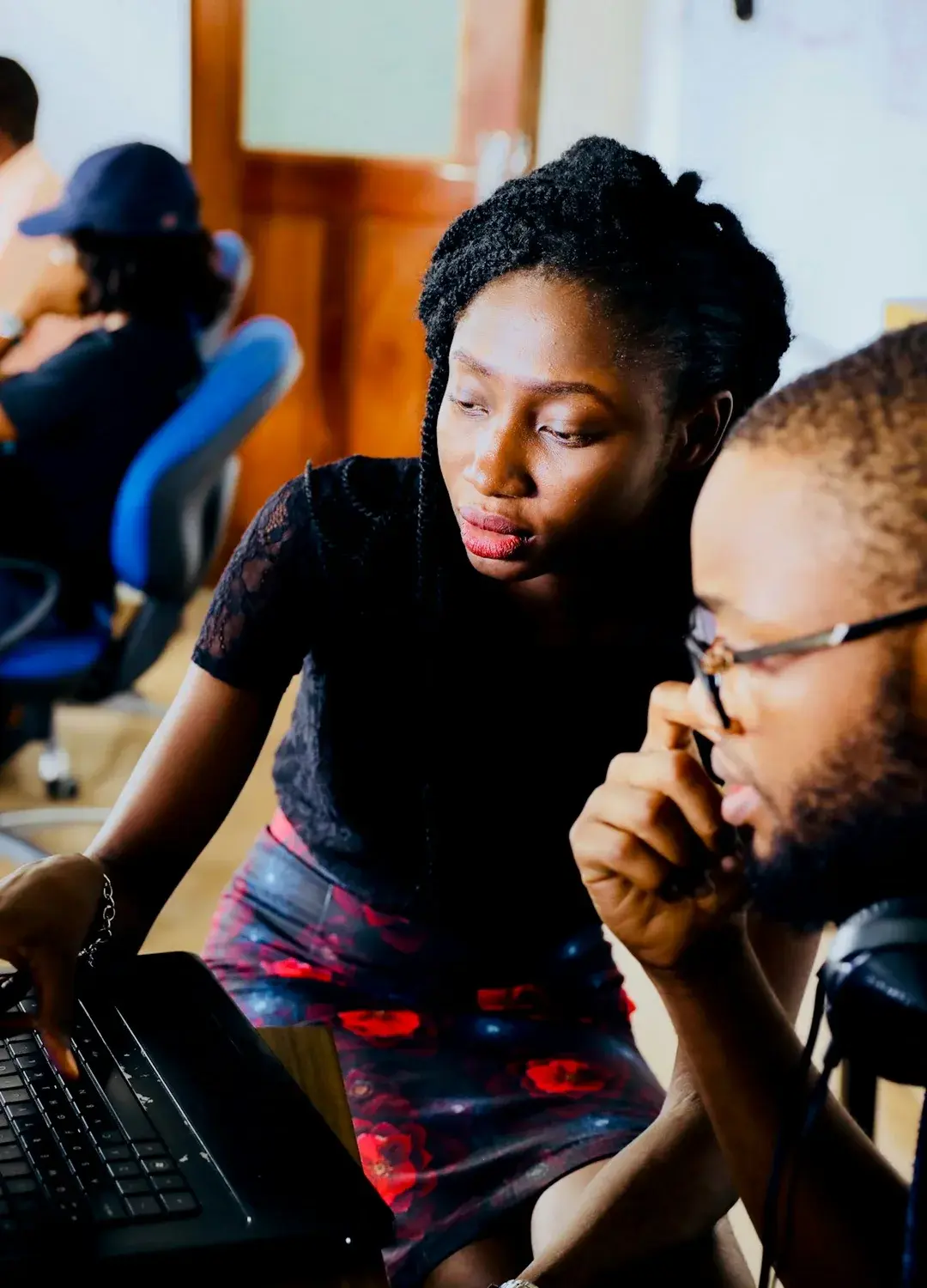 Two people reviewing work on a laptop